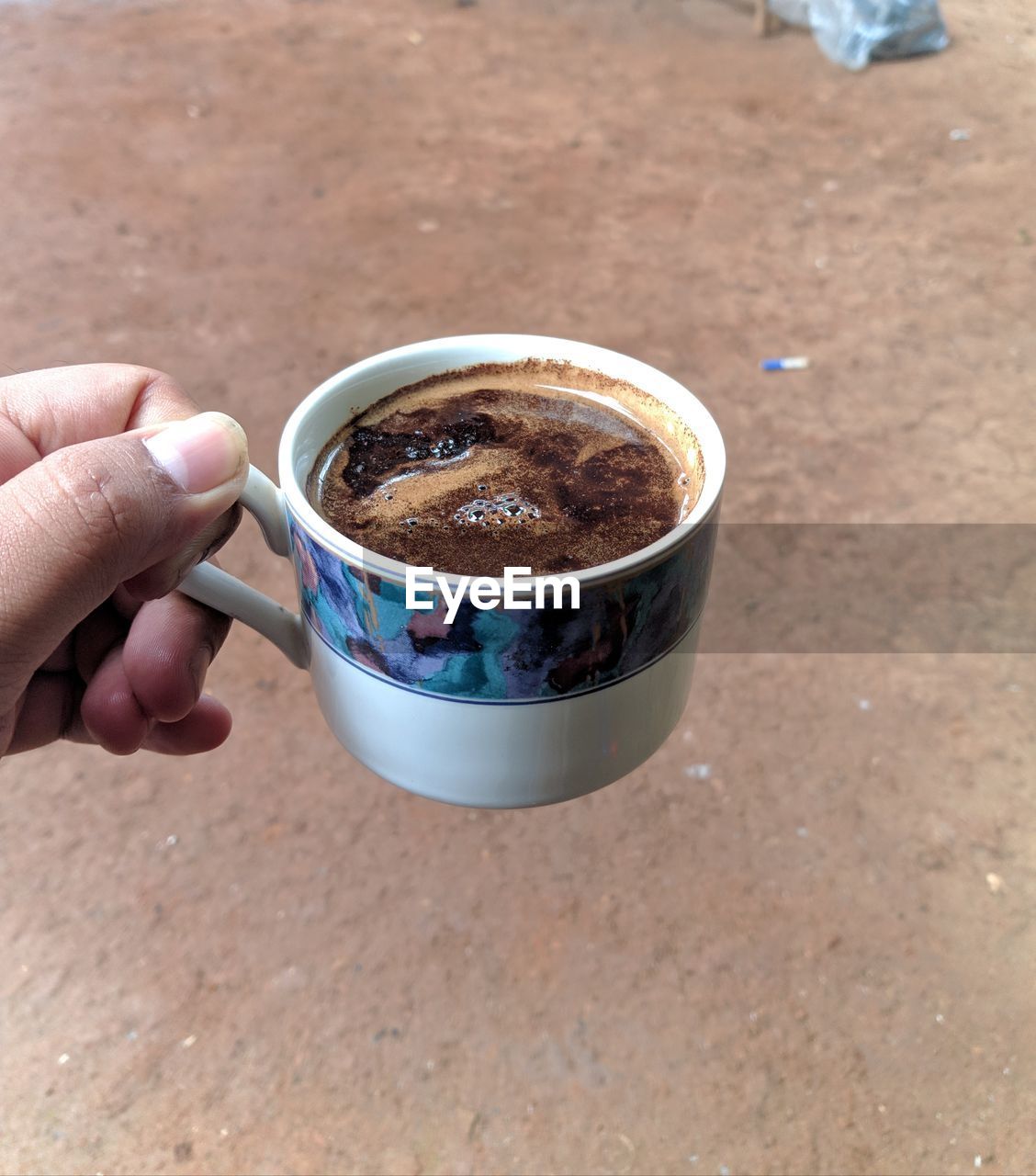 hand, food and drink, cup, holding, one person, drink, mug, refreshment, food, high angle view, coffee, lifestyles, day, coffee cup, adult, close-up, freshness, outdoors, focus on foreground, hot drink, nature