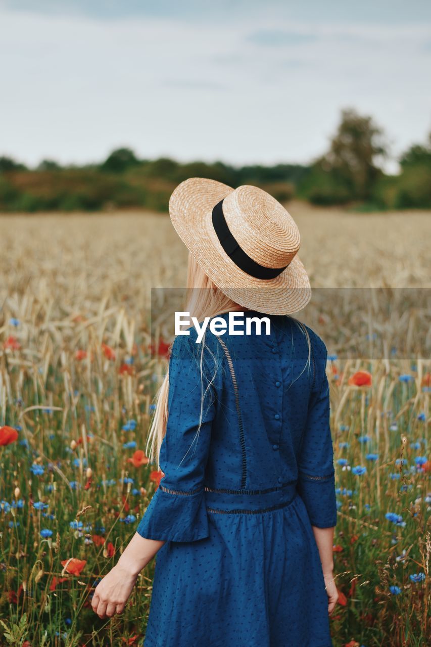 Rear view of woman standing in field