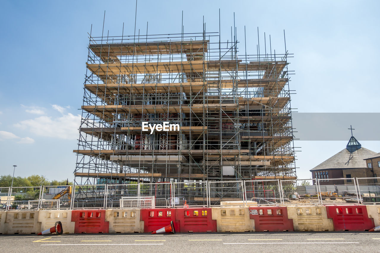 LOW ANGLE VIEW OF CONSTRUCTION SITE AGAINST BUILDING