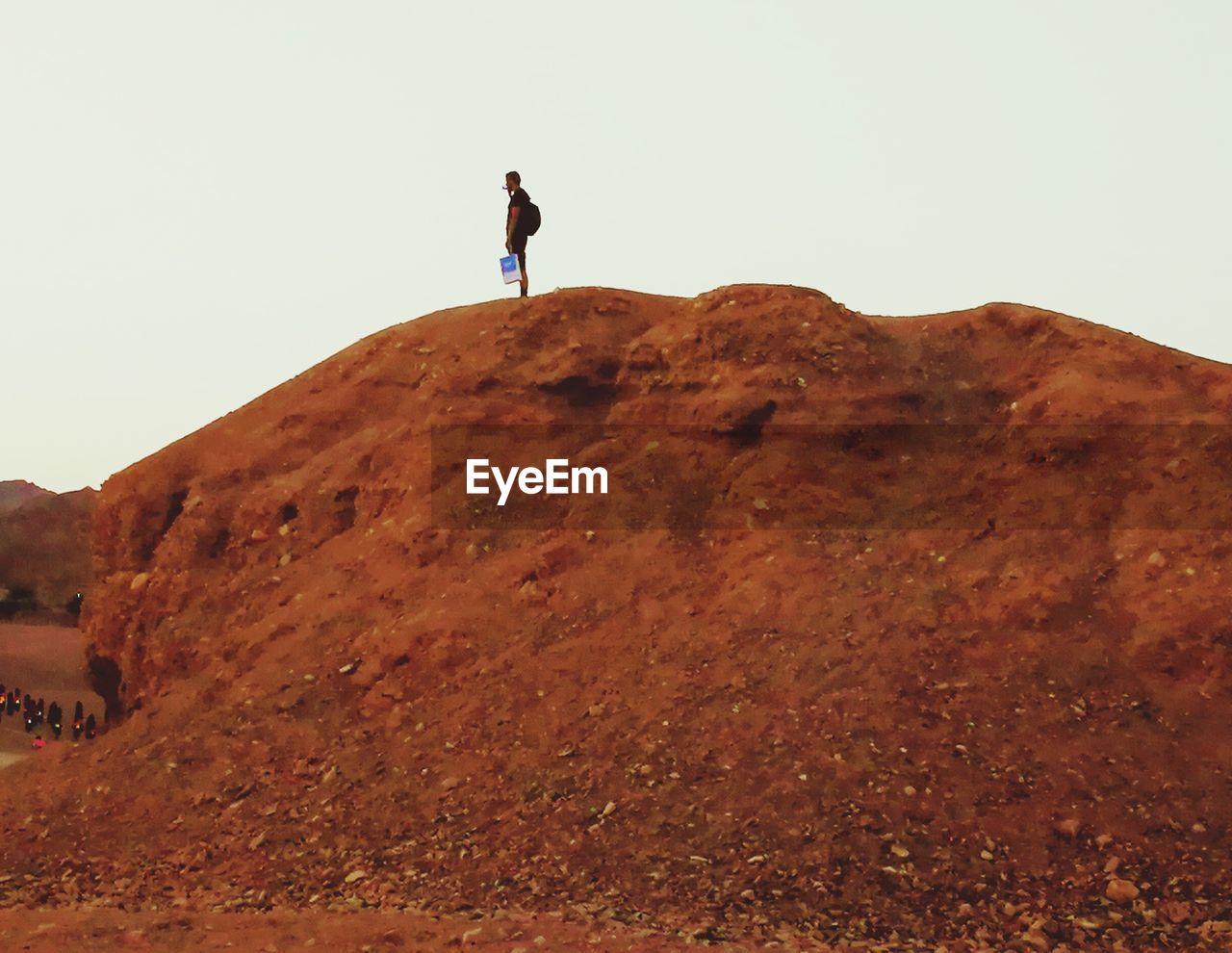 PEOPLE STANDING ON MOUNTAIN AGAINST SKY