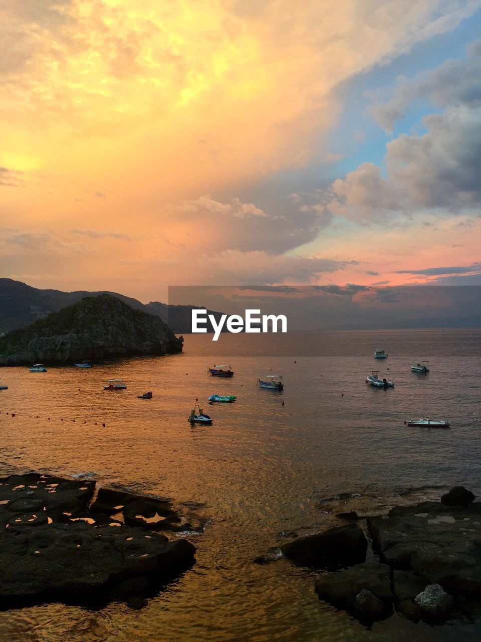 Boats in sea at sunset