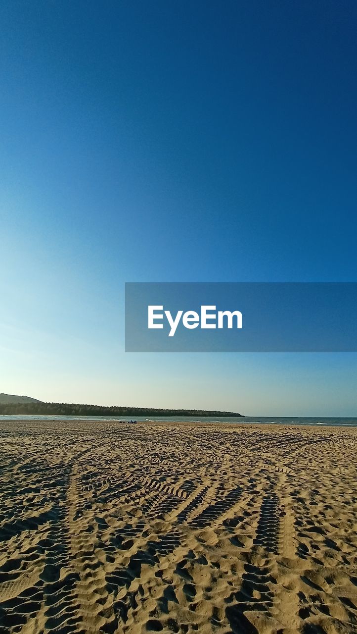 SCENIC VIEW OF SAND DUNE AGAINST CLEAR BLUE SKY