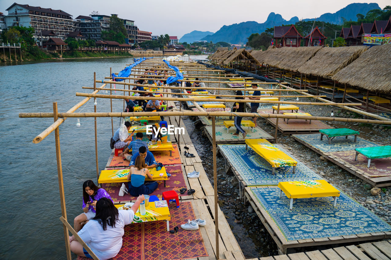 HIGH ANGLE VIEW OF PEOPLE ON BOATS IN RIVER