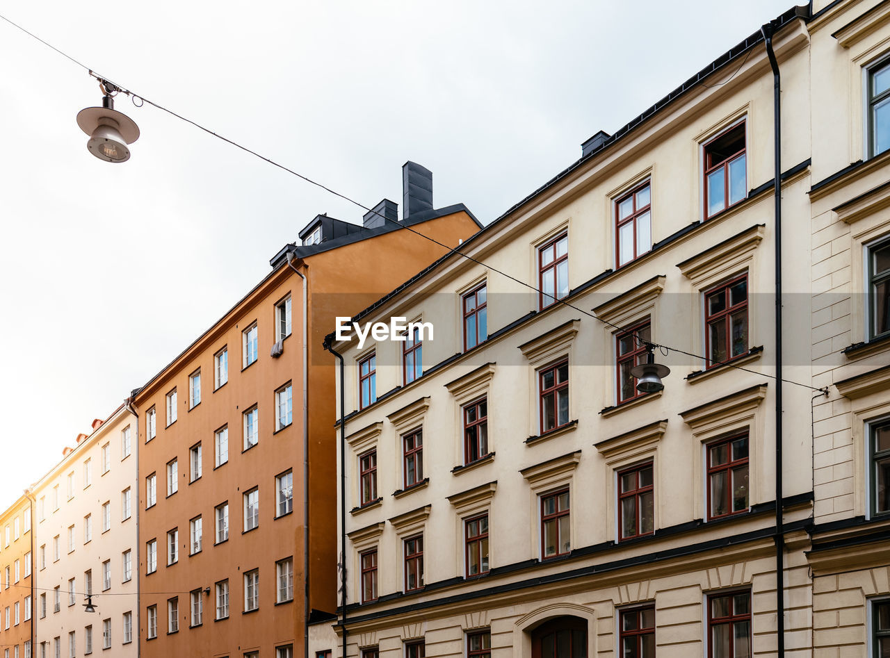 Low angle view of old residential buildings in sofo district in stockholm. sun flares