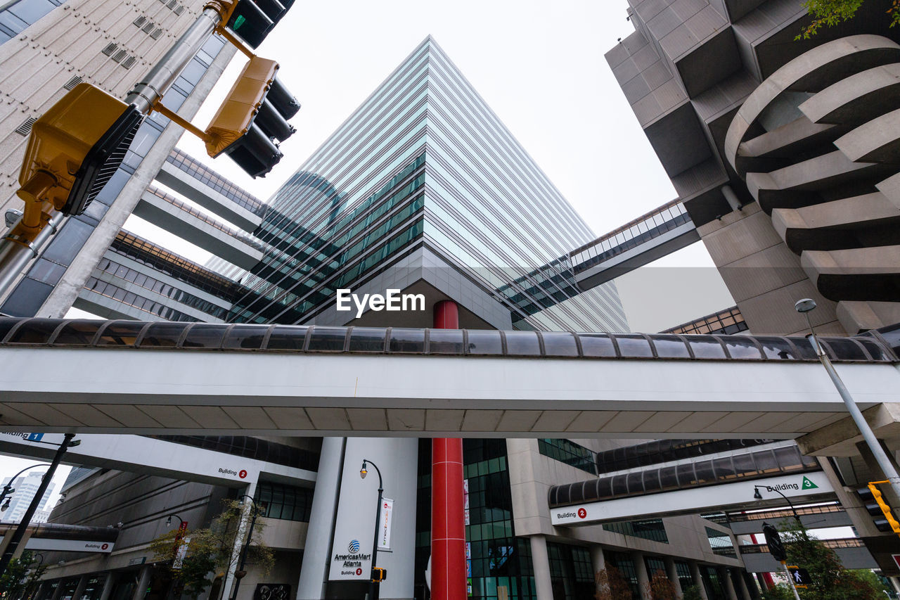 Low angle view of elevated walkway against modern buildings in city
