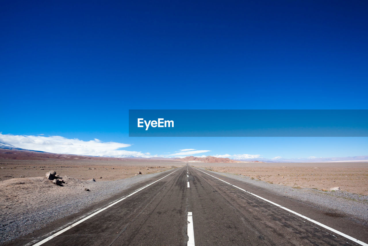 ROAD PASSING THROUGH DESERT AGAINST SKY