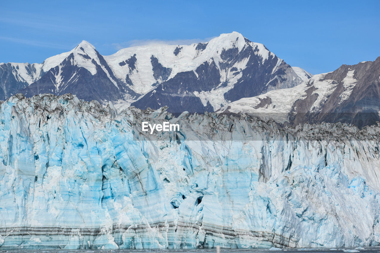 View of glacier with snowcapped mountains in backgrounds