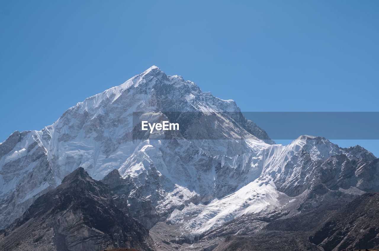 Scenic view of snowcapped mountains against clear blue sky