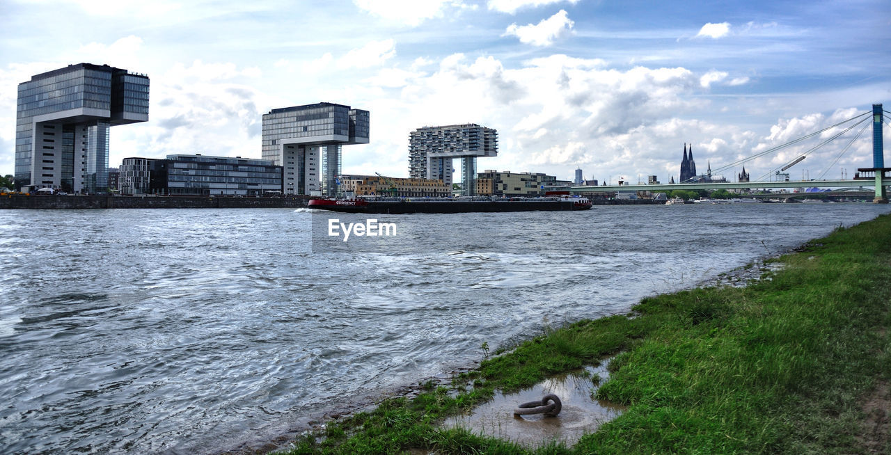 SCENIC VIEW OF RIVER AMIDST BUILDINGS AGAINST SKY