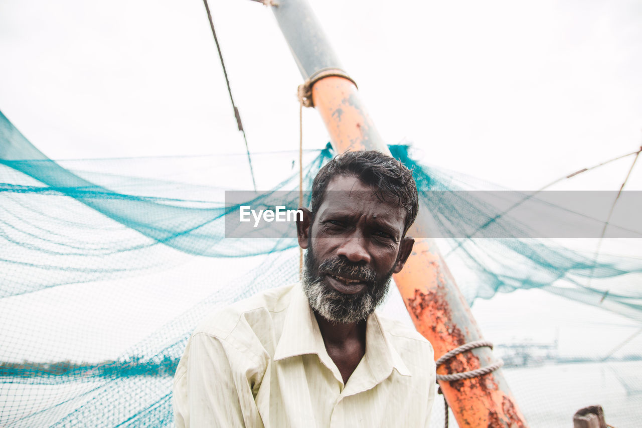 Portrait of fisherman by fishing net