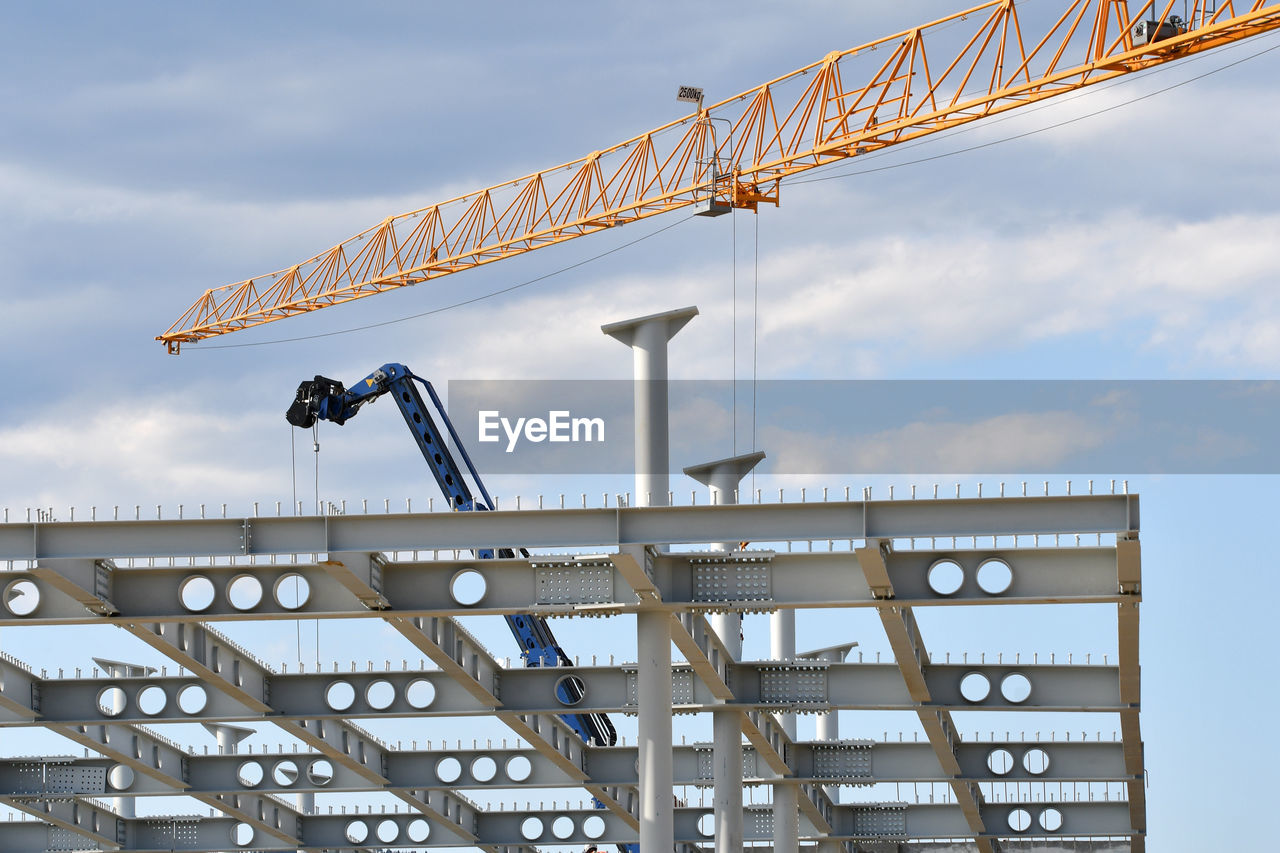 Low angle view of crane against sky