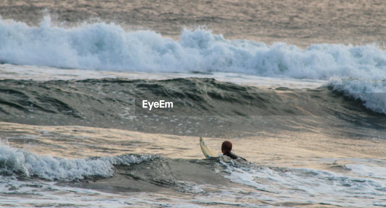 MAN SURFING ON BEACH