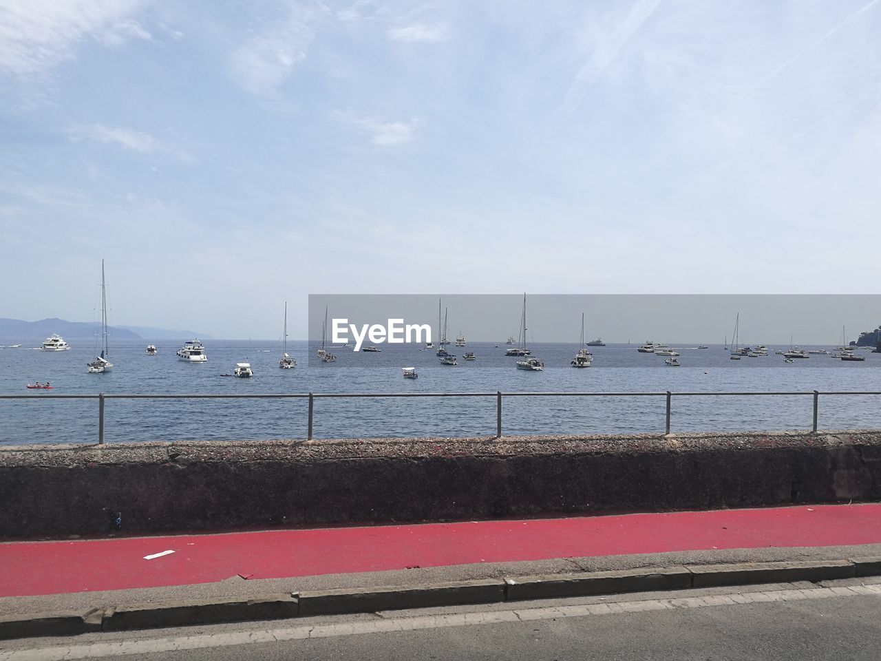 Sailboats moored at harbor against sky