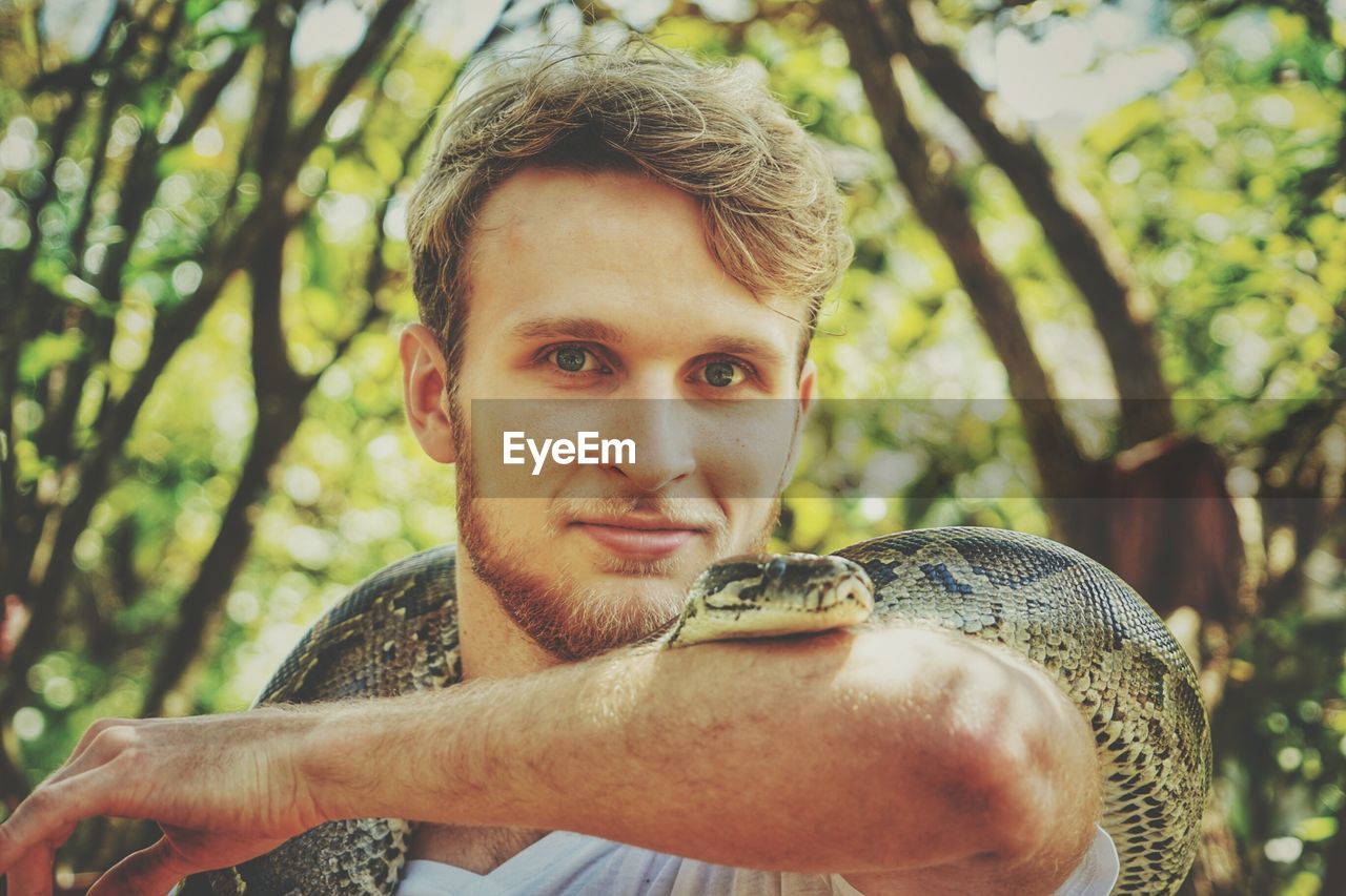 Portrait of young man with snake