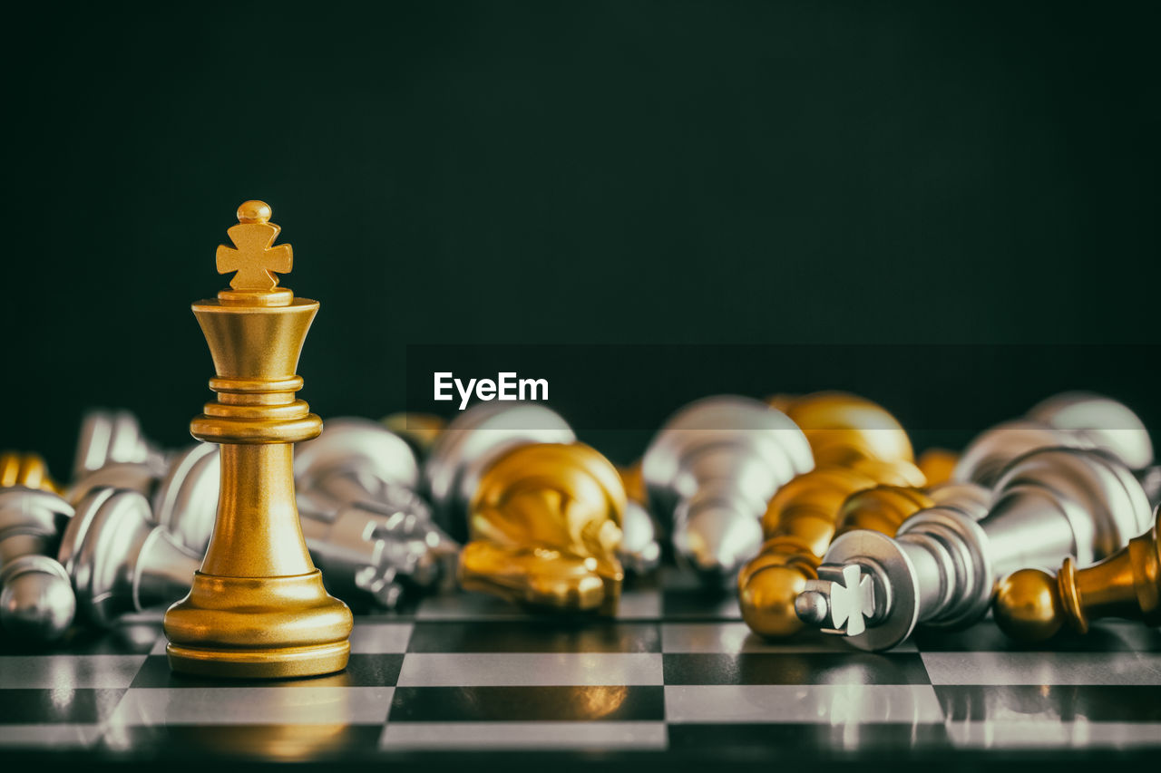 Close-up of chess pieces on board against black background