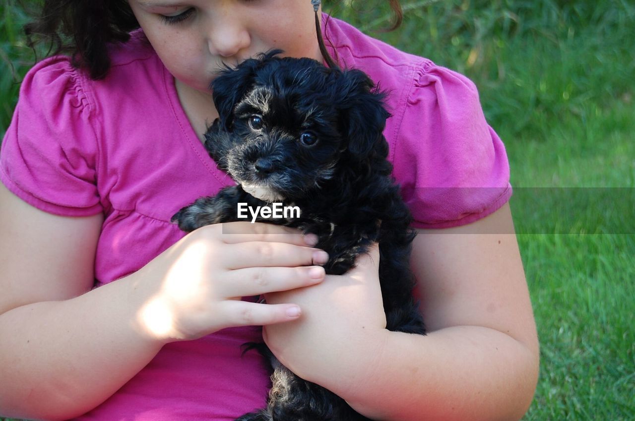 Close-up of girl holding puppy