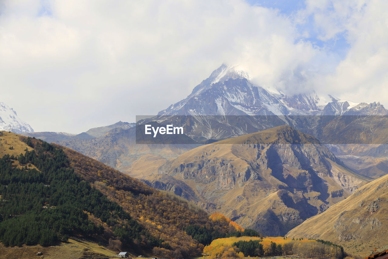 Scenic view of mountains against cloudy sky