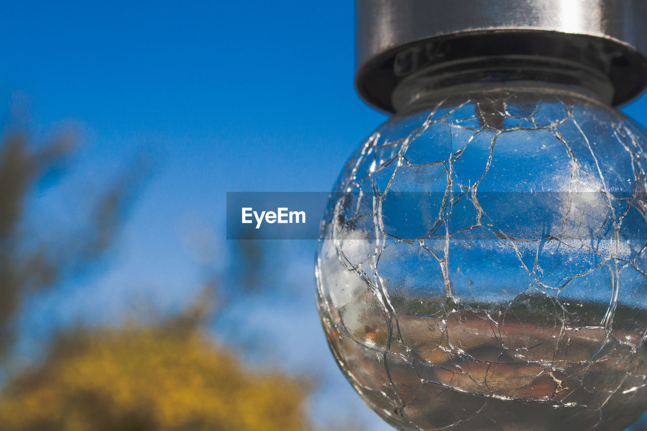 LOW ANGLE VIEW OF LIGHT BULB ON GLASS