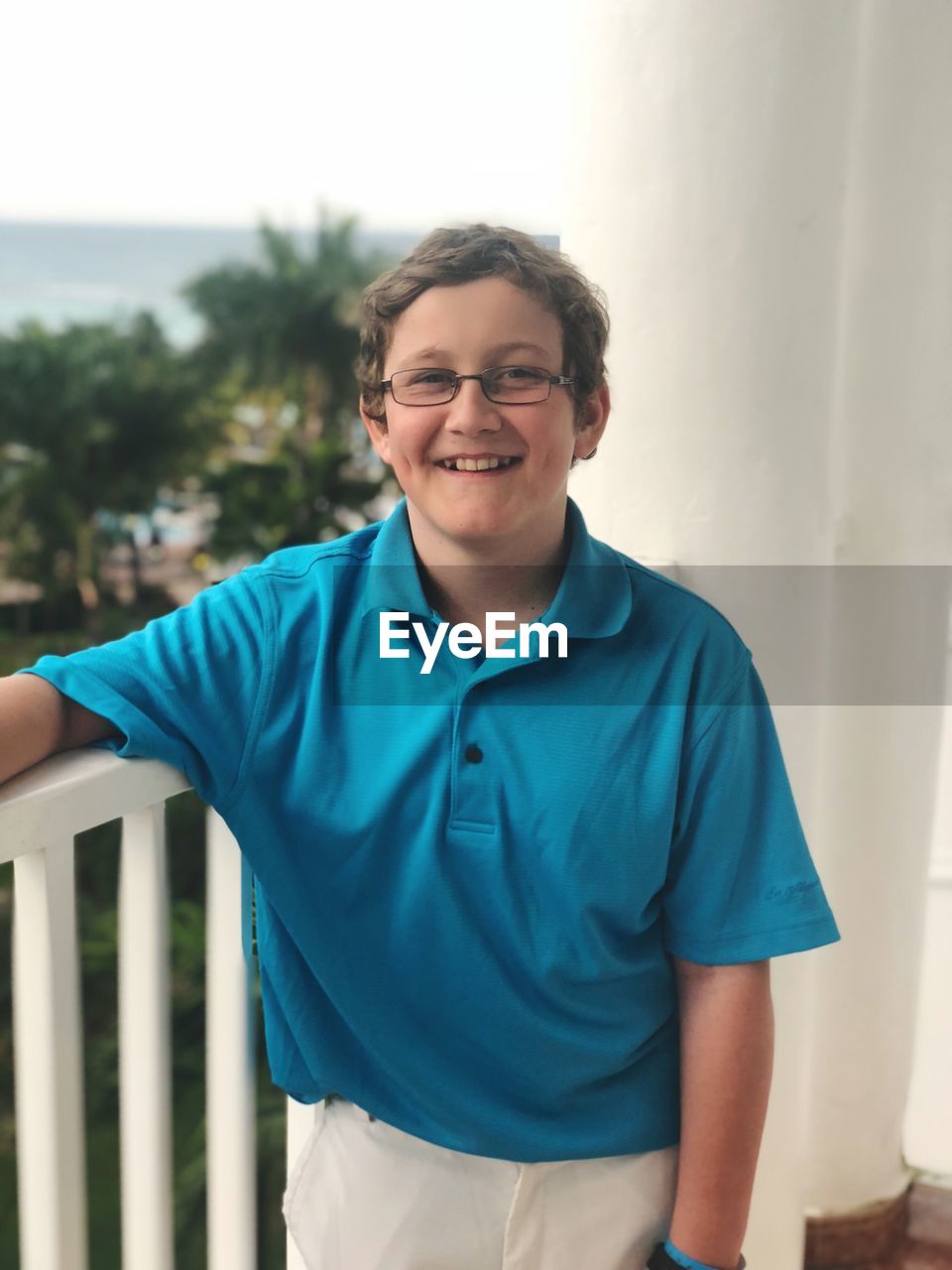 Portrait of smiling boy standing in balcony