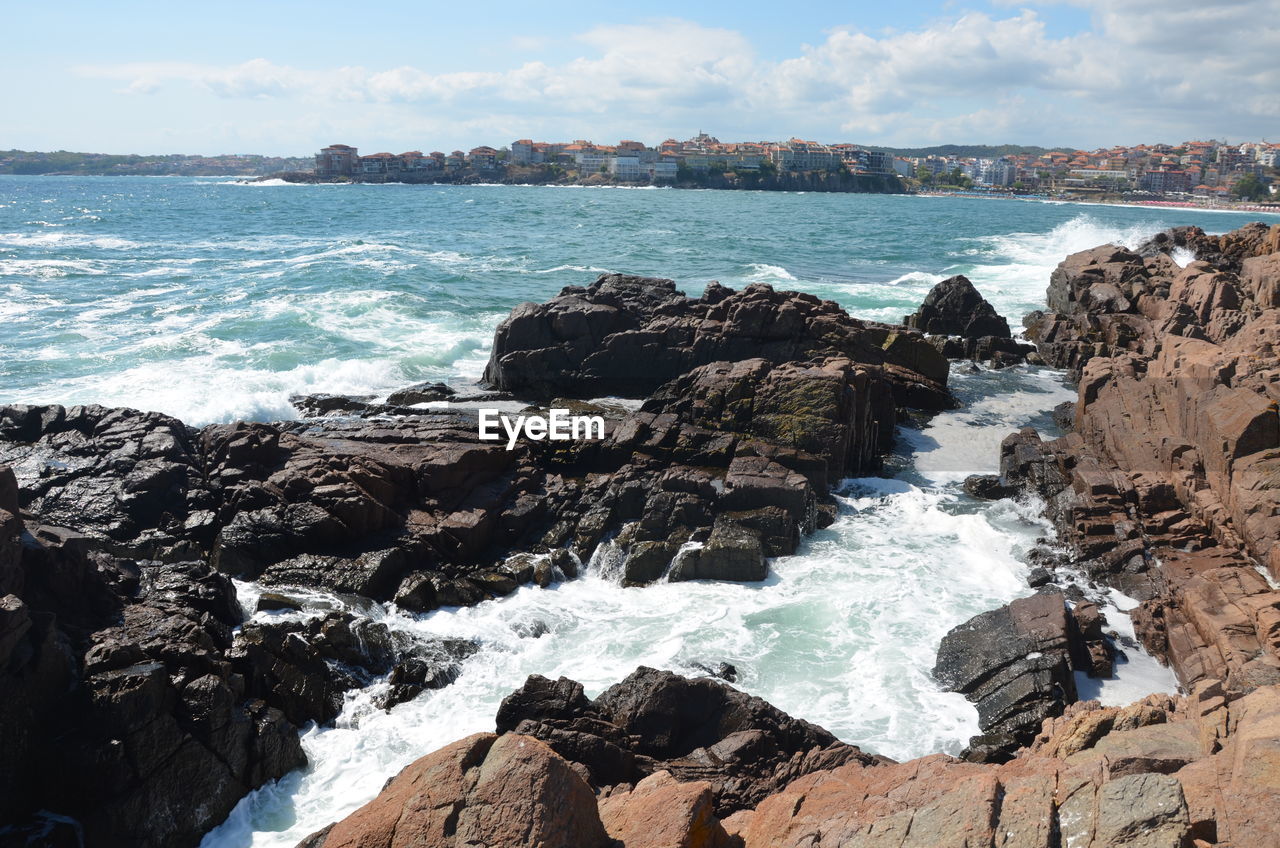 Scenic view of rocks in sea against sky