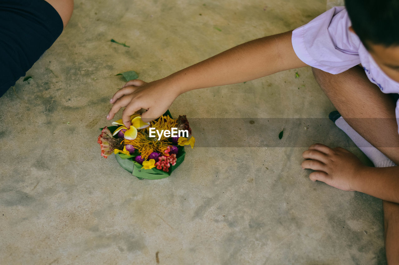 High angle view of boy holding religious offering