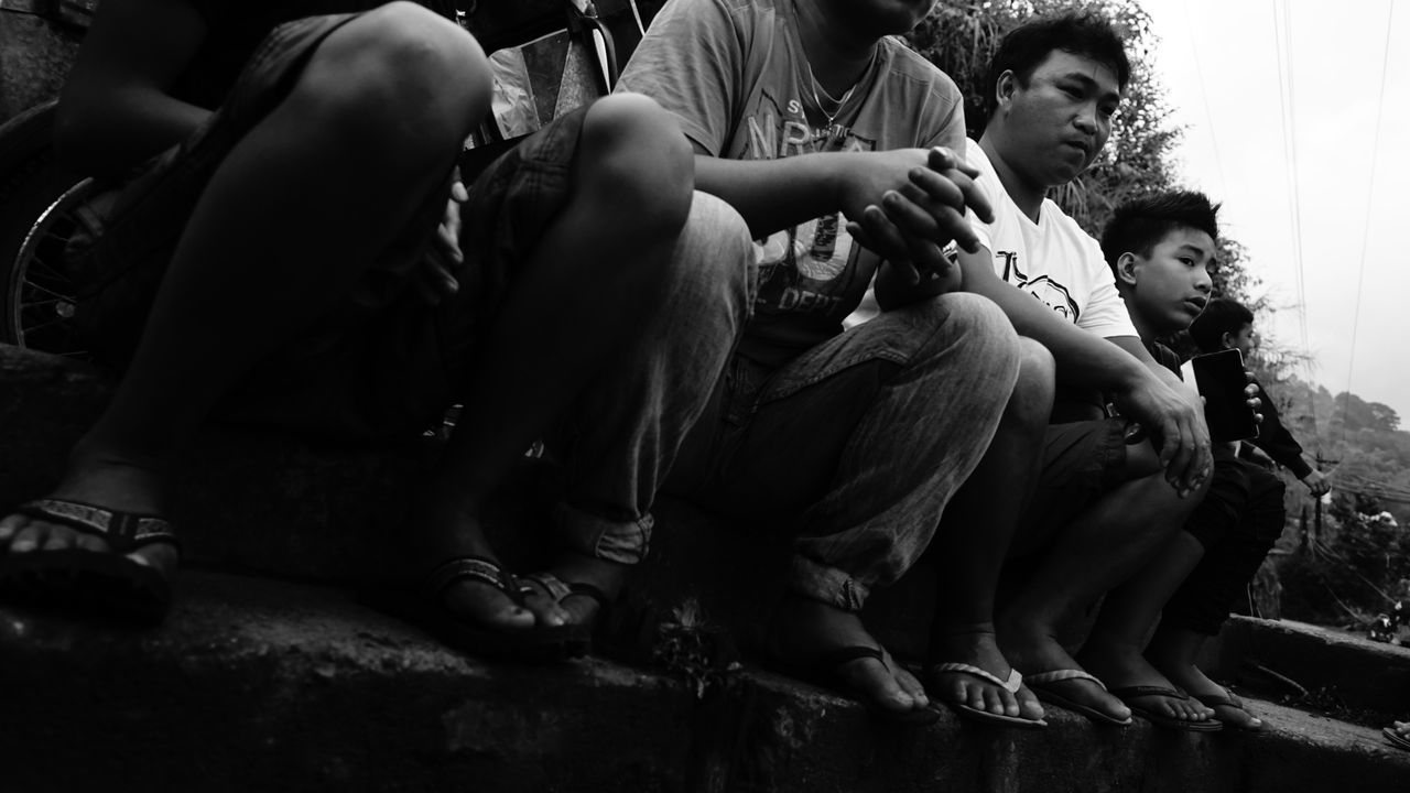 REAR VIEW OF COUPLE SITTING OUTDOORS