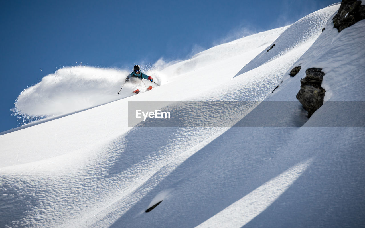 Low angle view of man skiing on snow covered mountain