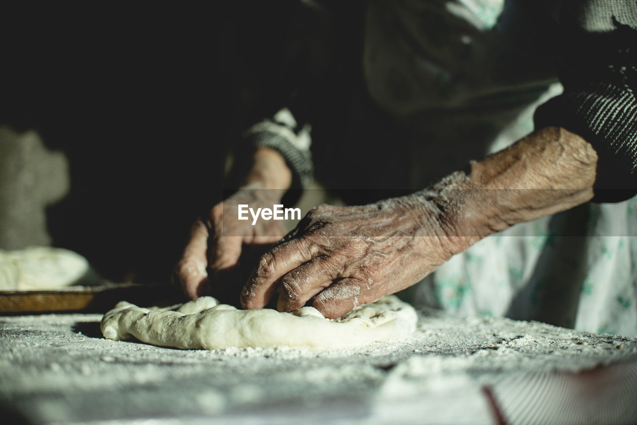 Georgian old woman is bakind bread.