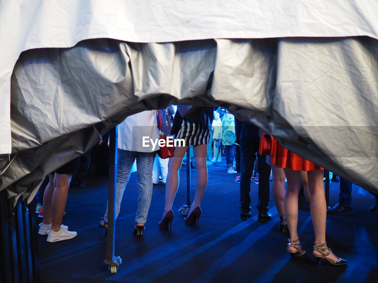 Low section of people standing on footpath at night