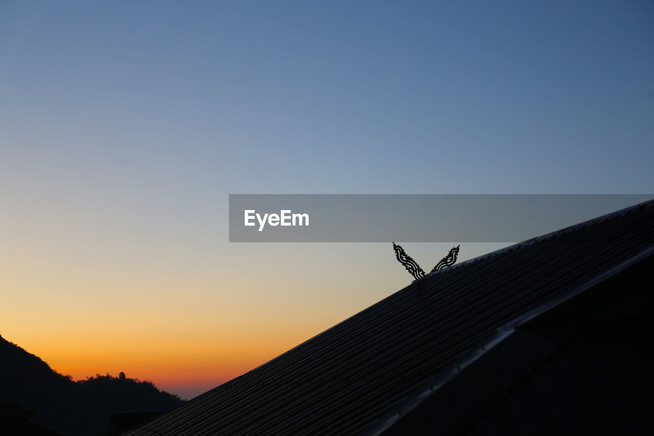 LOW ANGLE VIEW OF SILHOUETTE ROOF AGAINST SKY