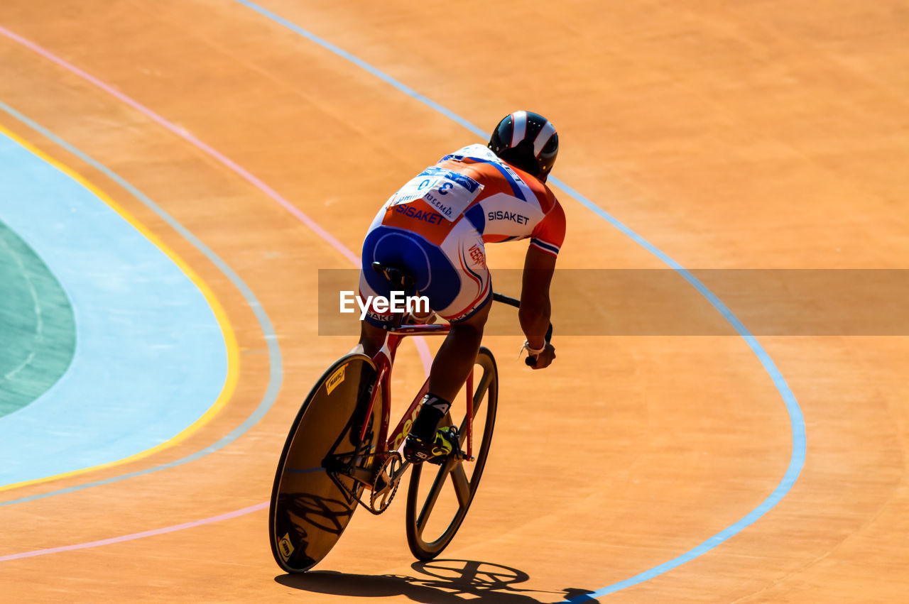 MAN RIDING BICYCLE WITH UMBRELLA