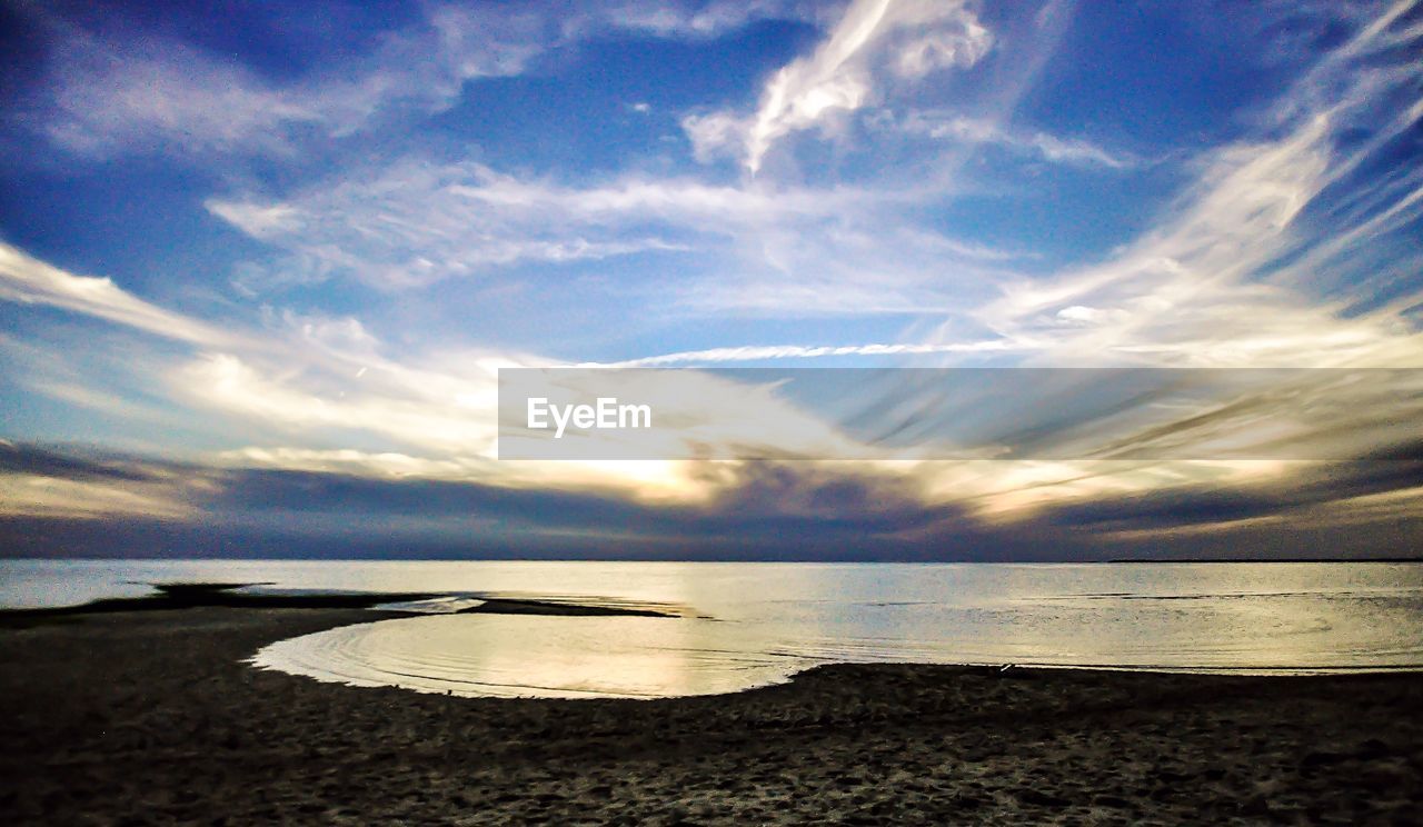 Scenic view of beach against sky during sunset