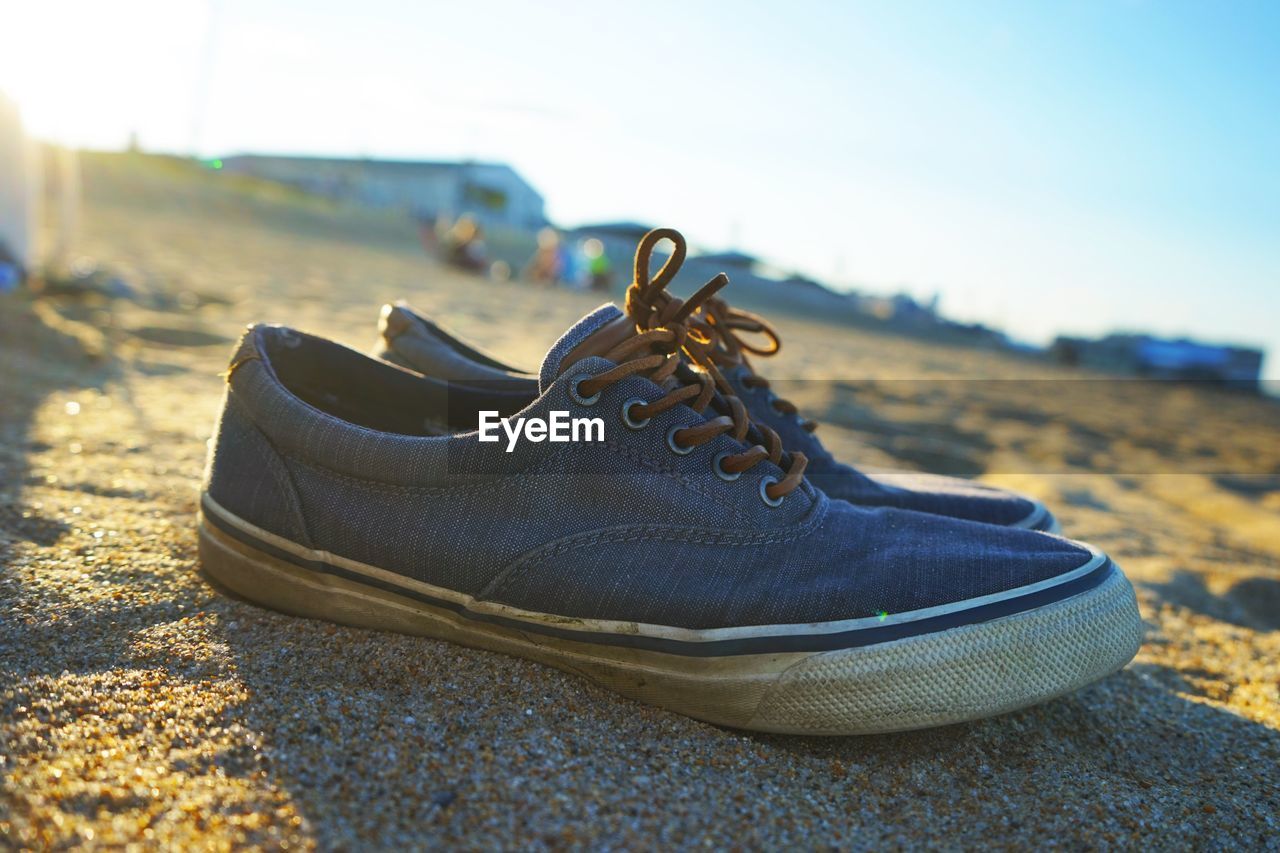 Close-up of shoes on sand