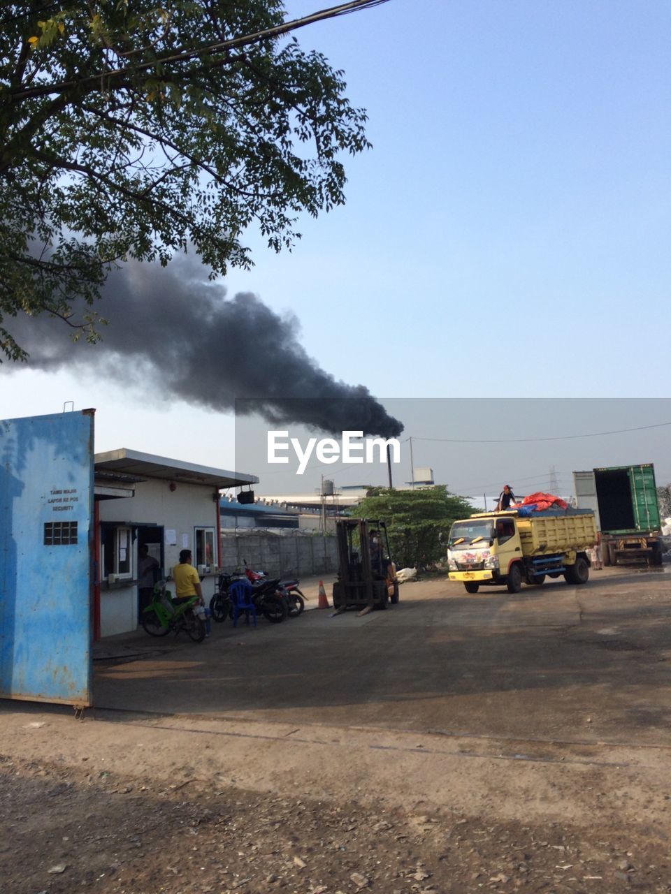 Smoke emitting from chimney of industry against clear sky