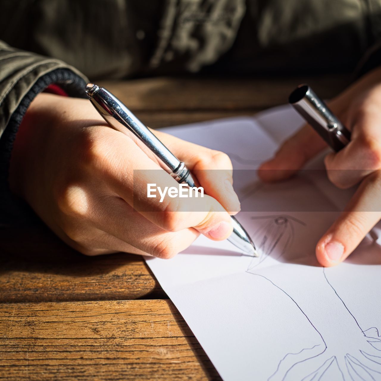 Midsection of woman drawing on paper