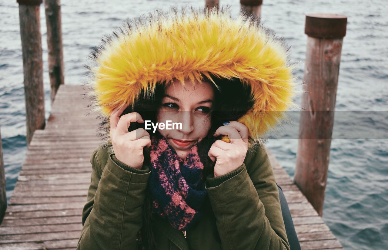 PORTRAIT OF BEAUTIFUL YOUNG WOMAN STANDING ON SNOW