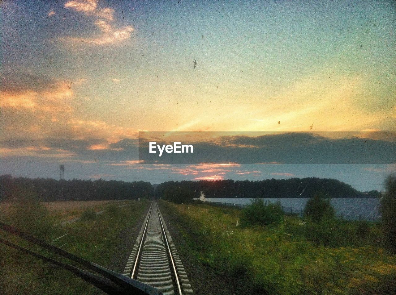Railway tracks and landscape seen through train windshield