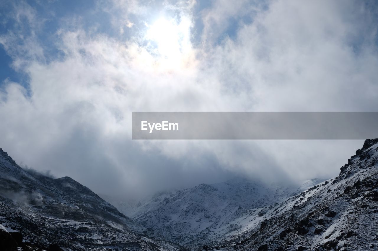 LOW ANGLE VIEW OF CLOUDS OVER MOUNTAIN