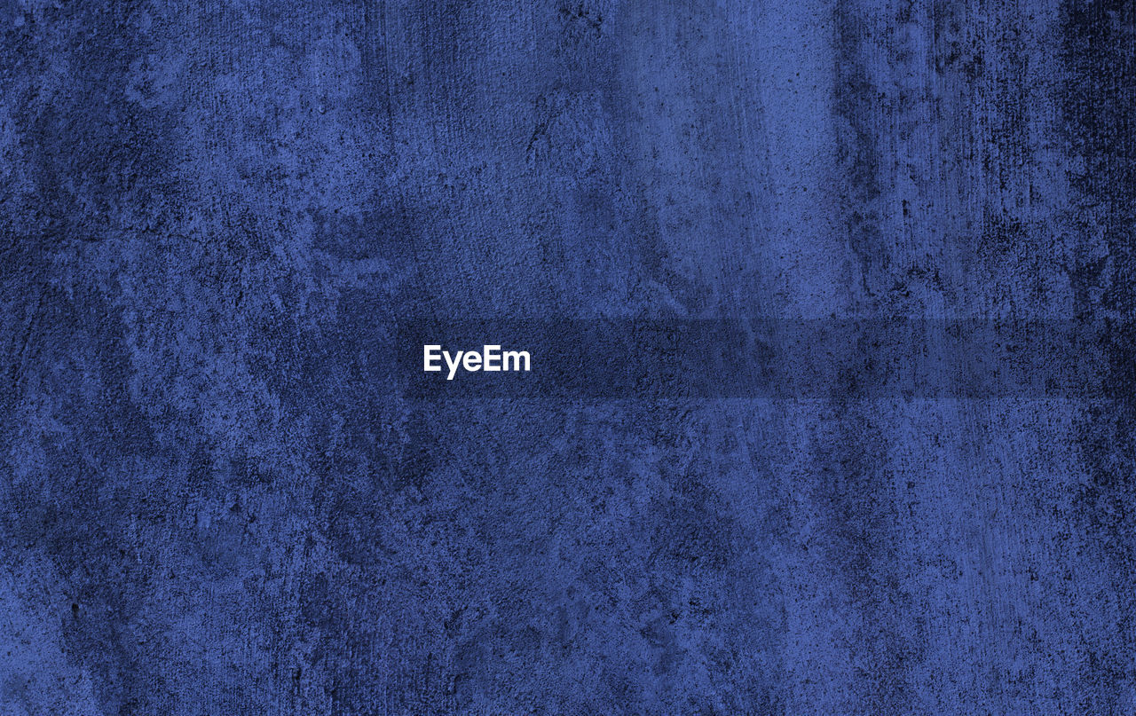 FULL FRAME SHOT OF BLUE WALL WITH ABSTRACT BACKGROUND