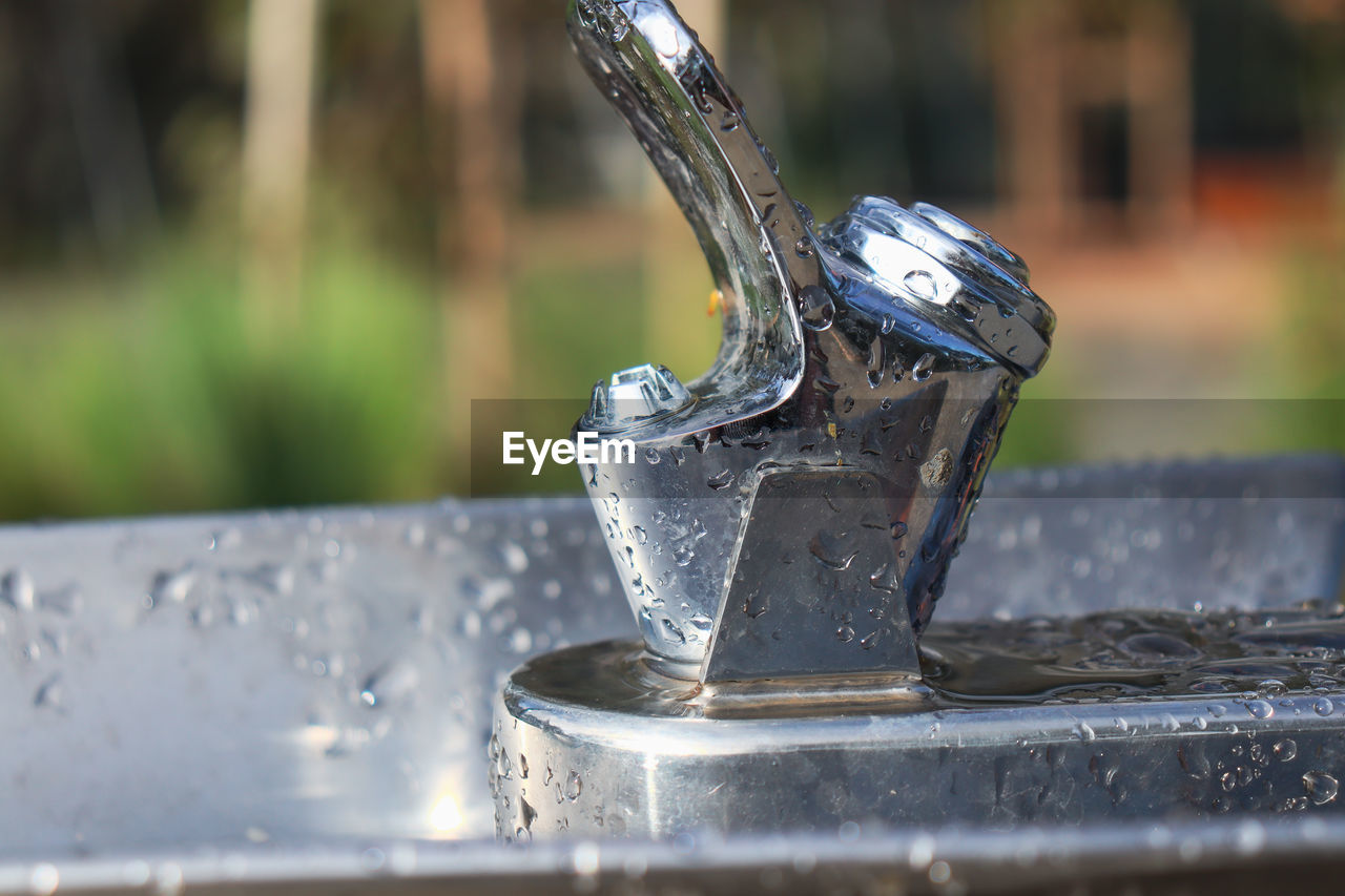 Close-up of water drops on metal water fountain