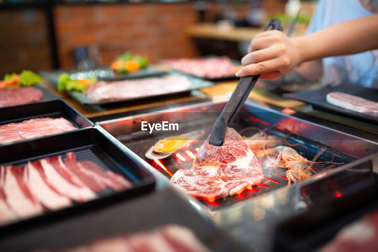 Cropped hand preparing meat