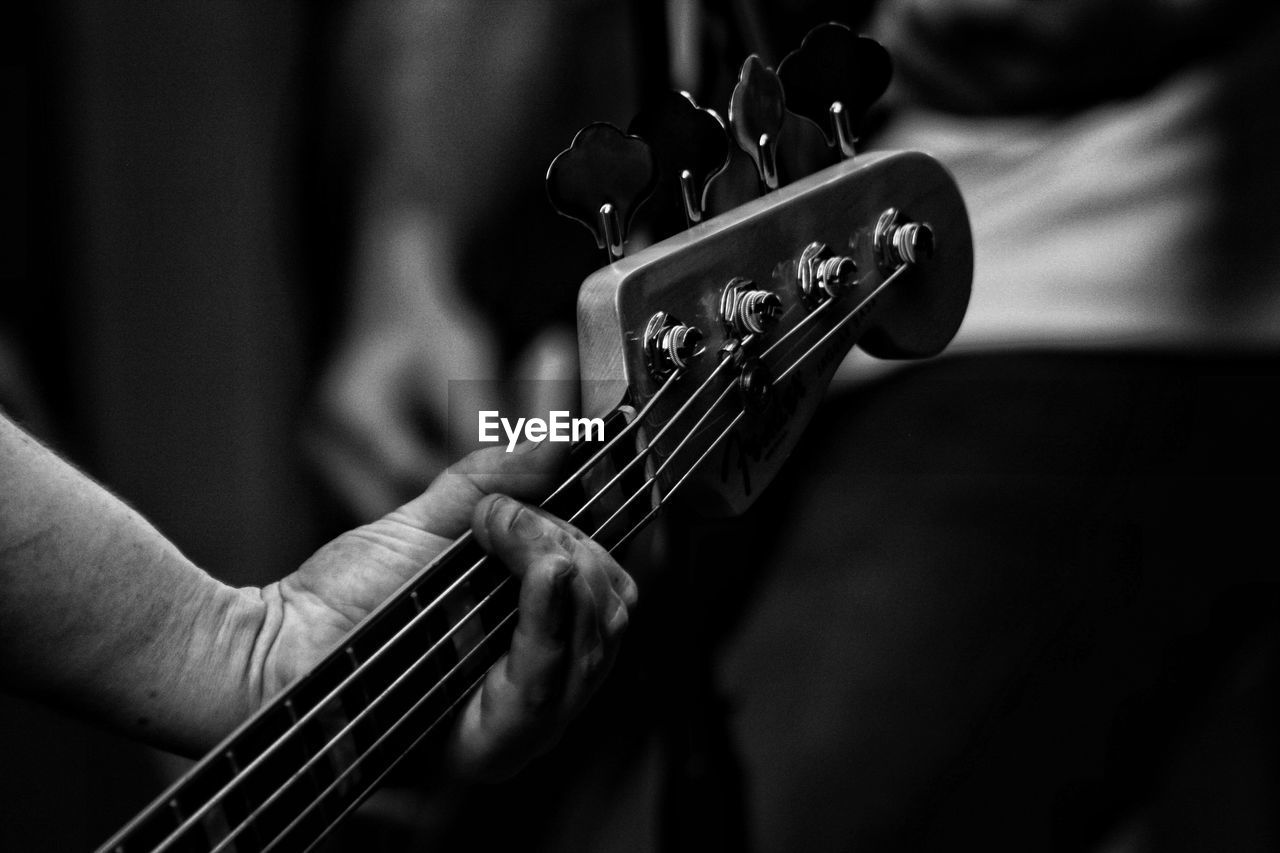 Cropped hand of man playing guitar