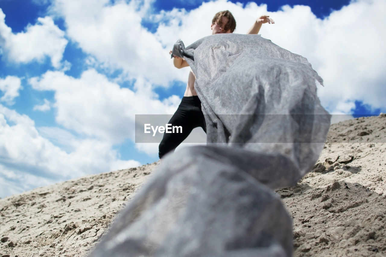 Low angle view of man holding textile