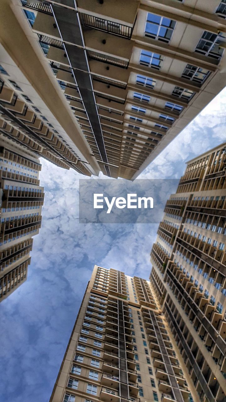 LOW ANGLE VIEW OF MODERN BUILDINGS AGAINST SKY IN CITY