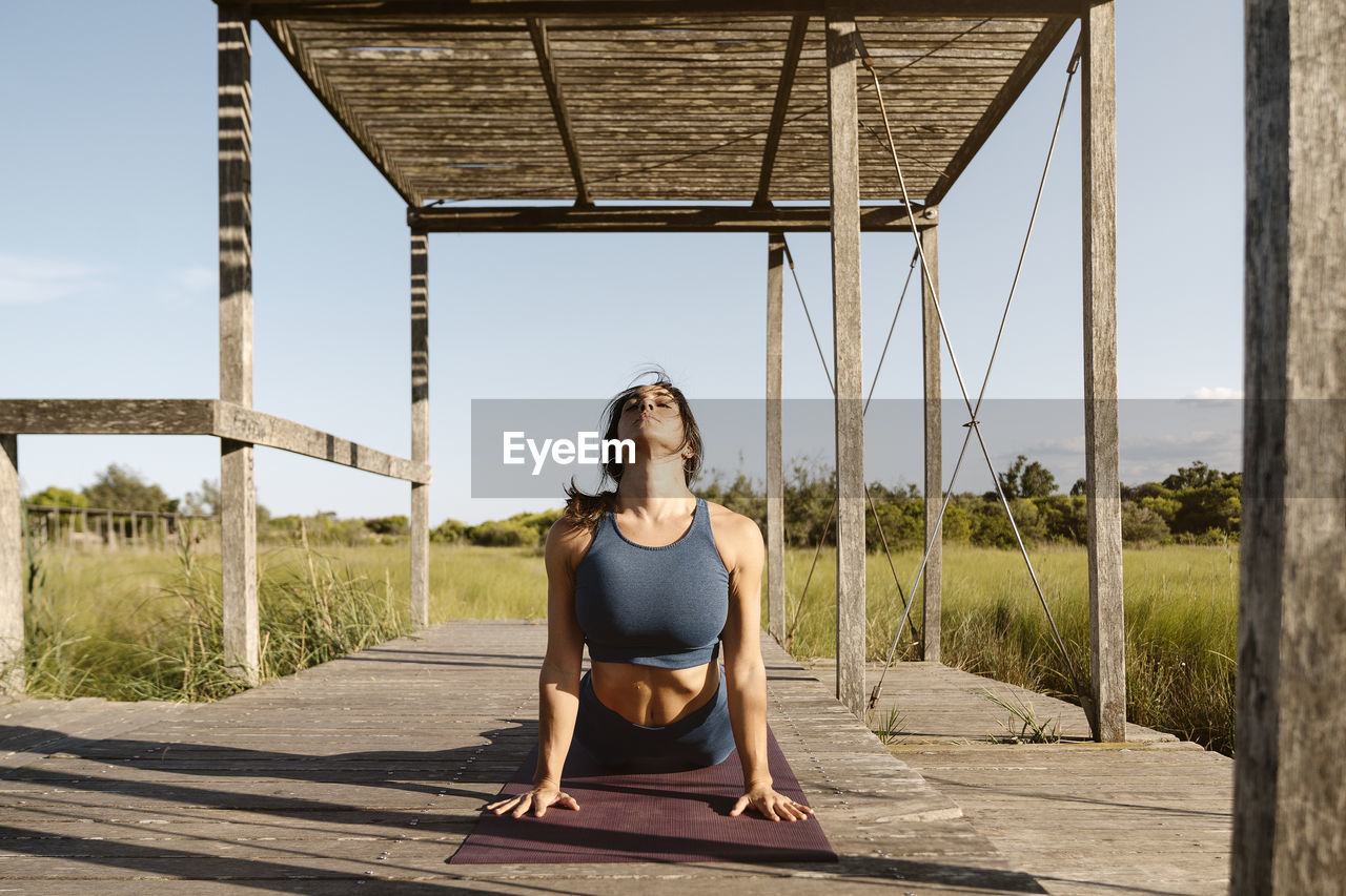 Woman doing urdhva mukha svanasana at gazebo