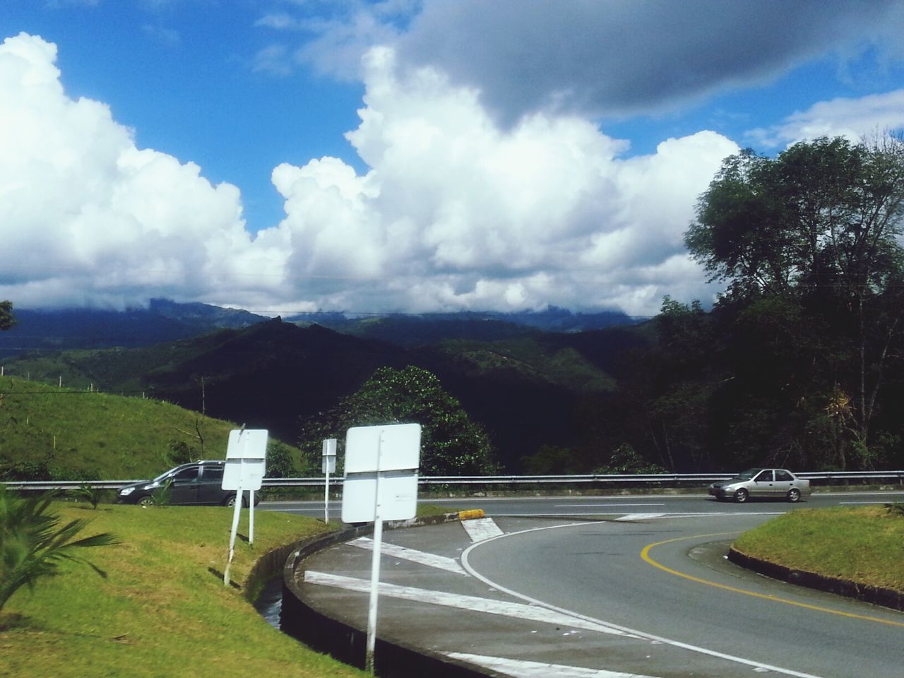 EMPTY ROAD WITH MOUNTAINS IN BACKGROUND