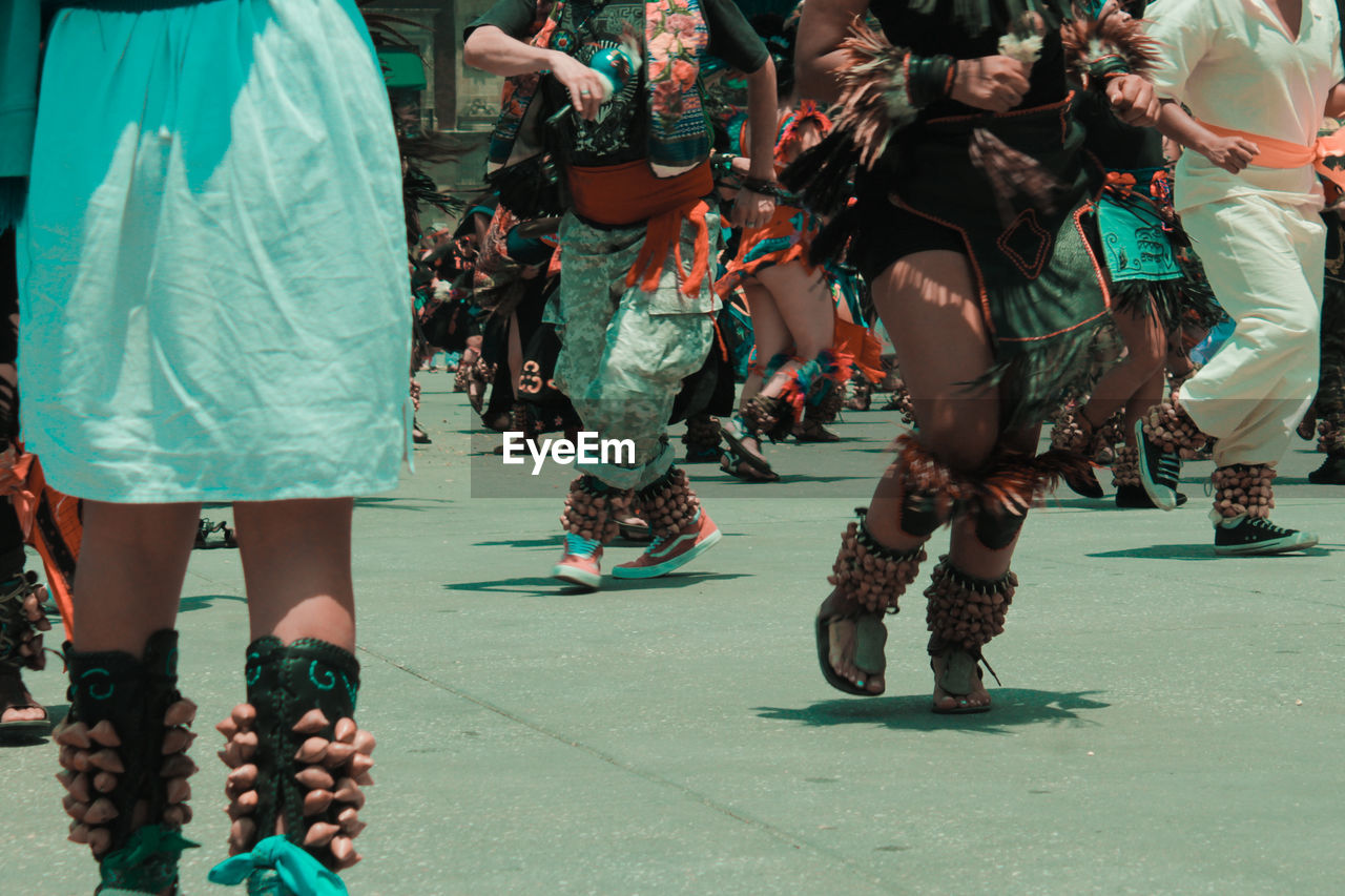 group of people, costume, footwear, arts culture and entertainment, adult, crowd, performance, traditional clothing, clothing, city, event, low section, day, women, dancing, street, large group of people