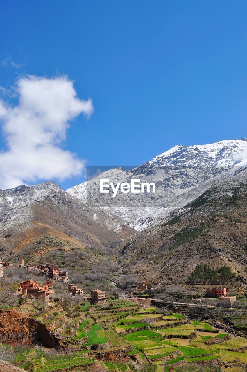 Scenic view of snowcapped mountains against blue sky