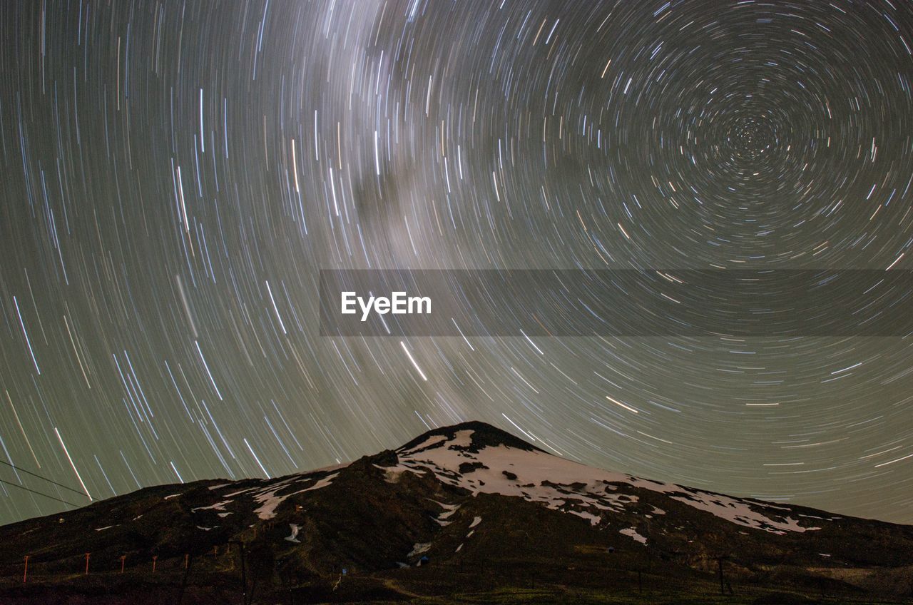 Low angle view of mountain and constellation in sky at night
