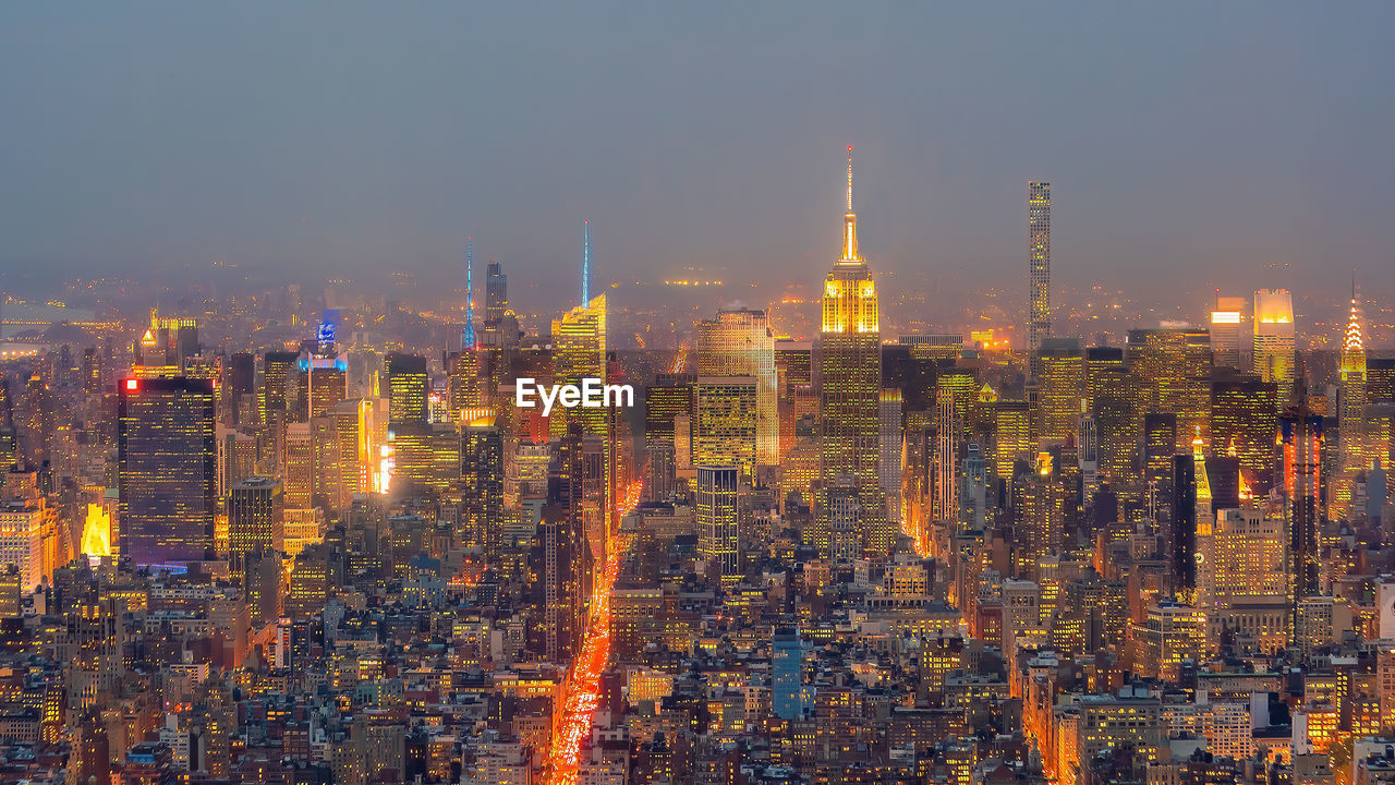 high angle view of illuminated buildings in city at night